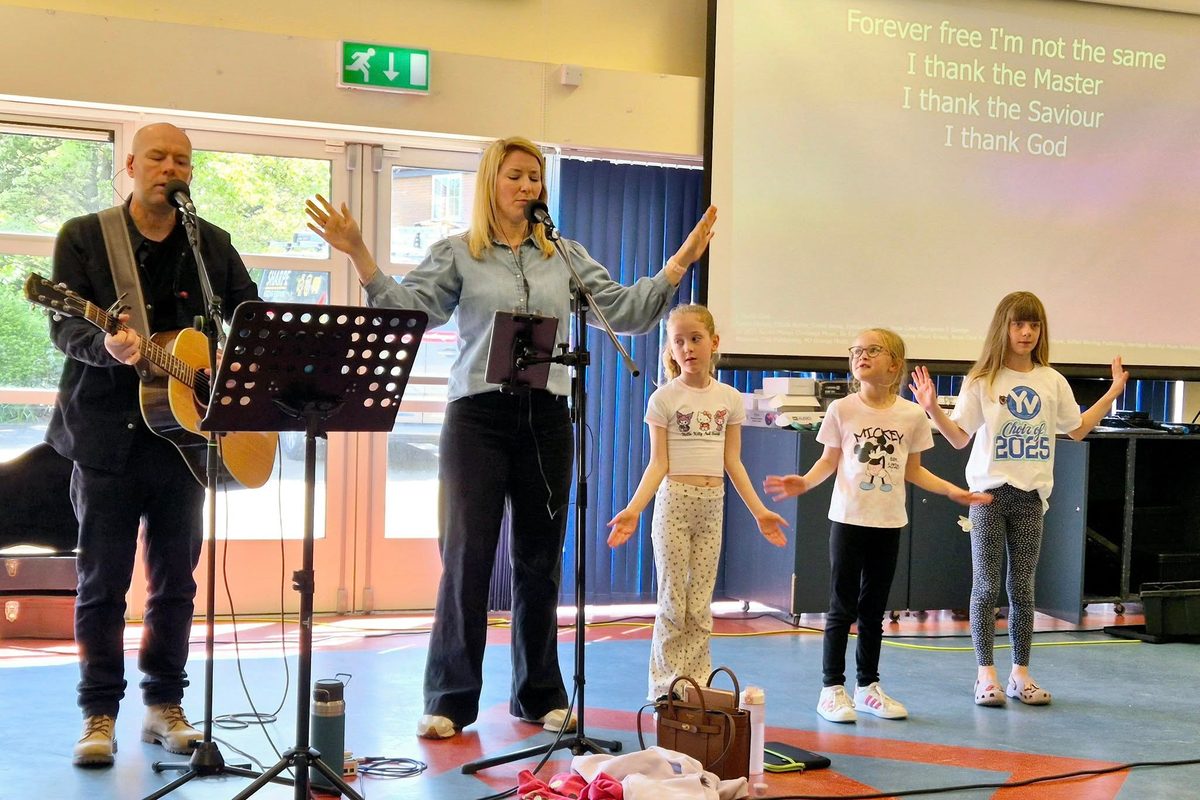 The band and children leading worship at a Sunday service in the school hall